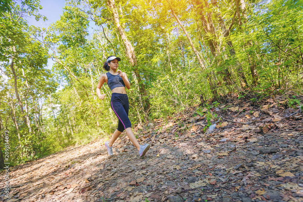Young woman runner athlete running on forest trail. motion movement Young woman runner athlete running on forest trail. motion movement