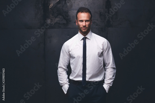 handsome man wearing white shirt on a grunge background.