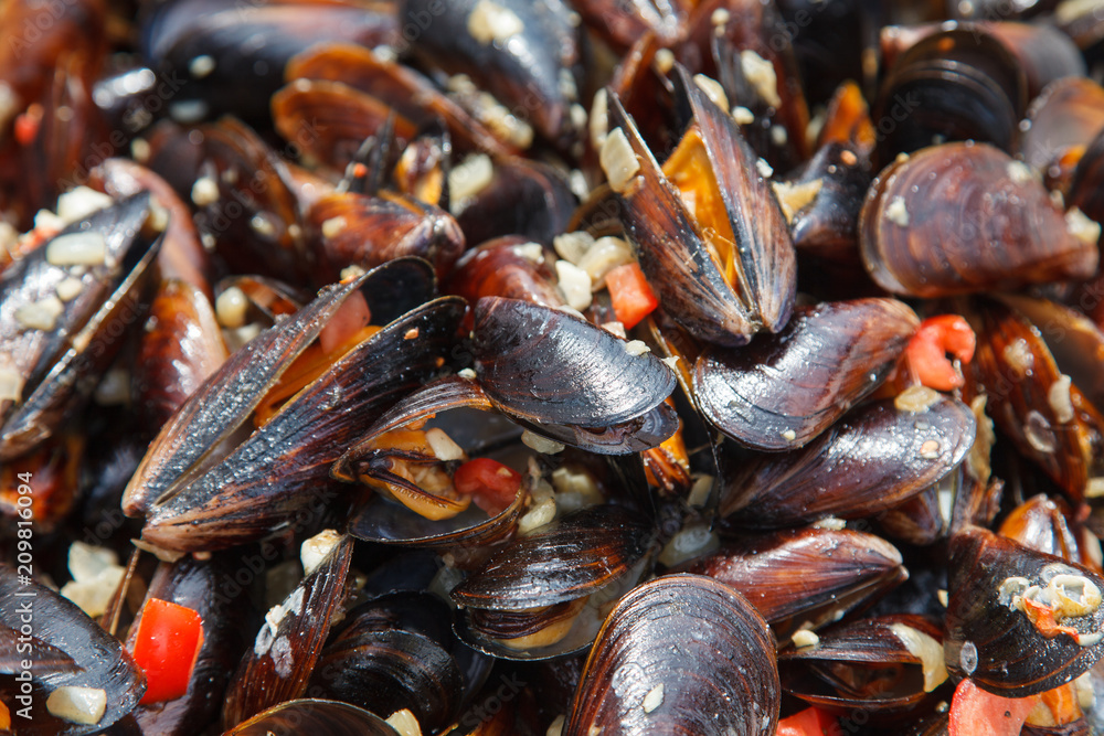 Mussels cooked in sauce with vegetables in a frying pan Mussels cooked in sauce with vegetables in a frying pan