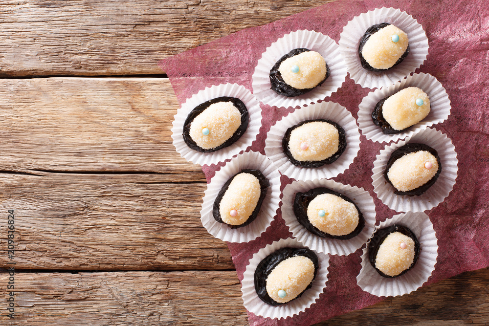 Brazilian dessert sweets Olho de sogra from condensed milk, prunes and coconut close-up. Horizontal top view Brazilian dessert sweets Olho de sogra from condensed milk, prunes and coconut close-up. Horizontal top view