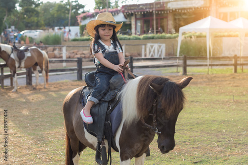 Canvas Print little girl is riding a horse