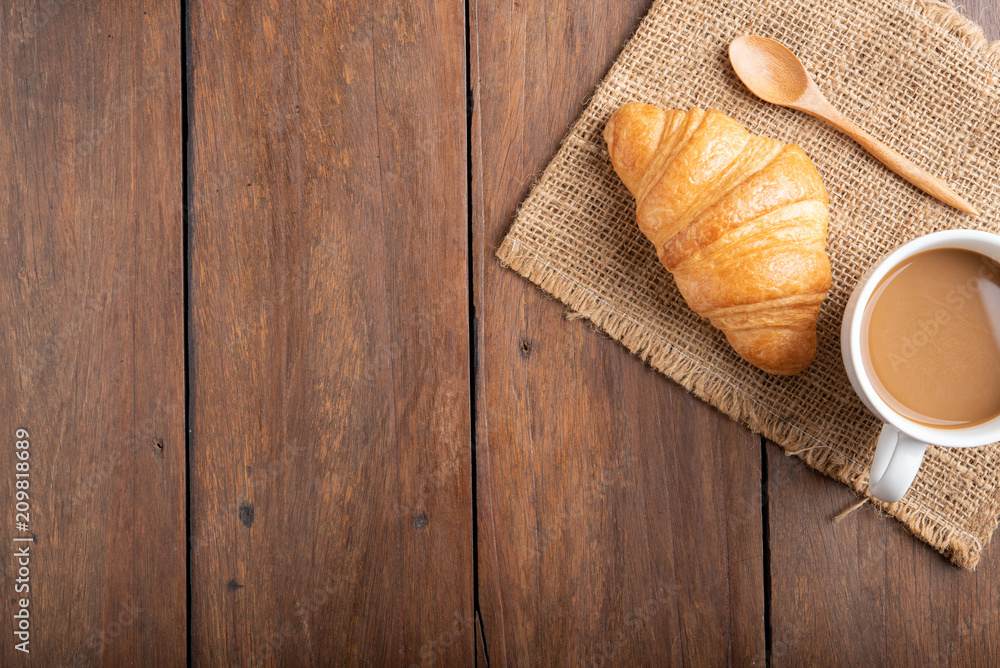 Coffee and croissant on wooden background Coffee and croissant on wooden background
