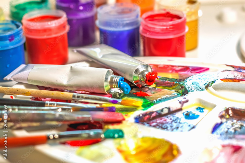 Palette of the artist with oil paints and brushes for drawing. close-up as an artistic background. Palette of the artist with oil paints and brushes for drawing. close-up as an artistic background.