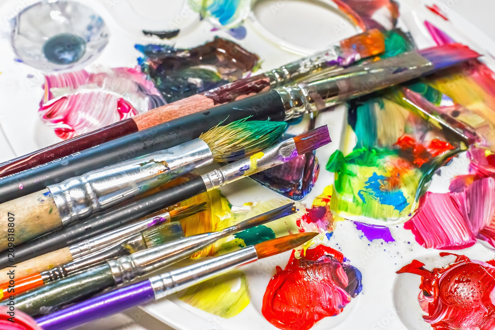 Palette of the artist with oil paints and brushes for drawing. close-up as an artistic background. Palette of the artist with oil paints and brushes for drawing. close-up as an artistic background.