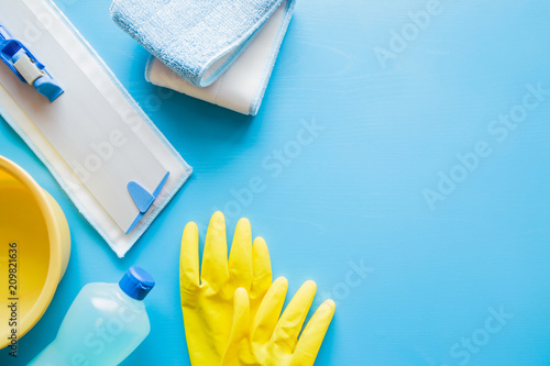 Professional cleaning set for different floor surfaces in kitchen  bathroom and other rooms. Empty place for text or logo on blue background. Cleaning service concept. Early spring regular clean up.