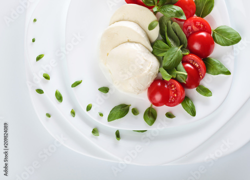 Mozzarella with tomato and green basil.