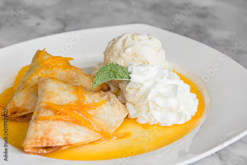 Crepes Suzette: French thin pancake with orange sauce and ice cream