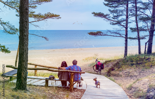 Happy couple of seniors are resting on wooden bench and  looking at the dista...