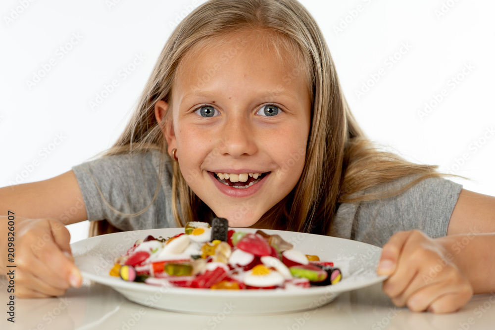 happy young girl holding a plate full of candy lollies on white background happy young girl holding a plate full of candy lollies on white background