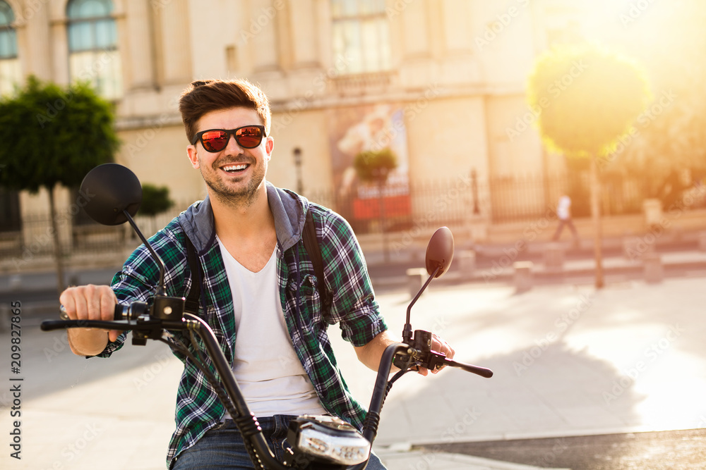 Fototapeta premium young man sitting on electric vehicle