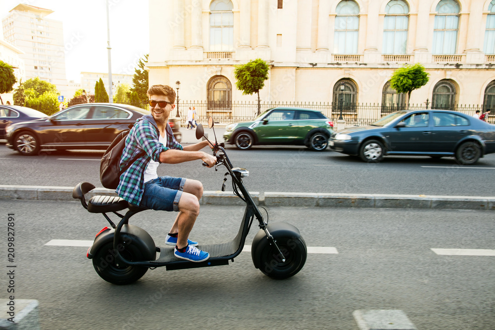 Obraz premium młody mężczyzna jedzie pojazdem elektrycznym