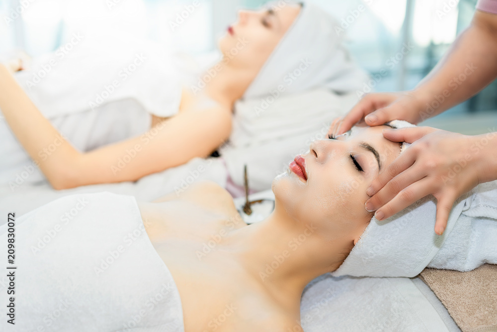 Spa treatment for good health.Beautiful woman lying and relaxing on massage bed.Woman having wellness body massage and feeling visibly good at spa salon.