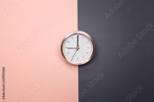 Rose gold clock on pastel pink and grey background. minimal idea business concept.