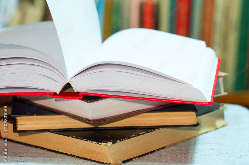 Open book, stack of hardback books on table. Top view. Open book, stack of hardback books on table. Top view.