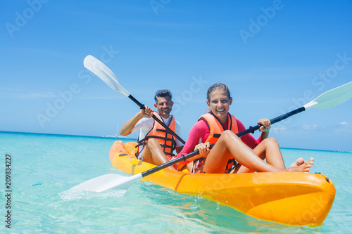 Fotótapéta Happy girl and her father kayaking at tropical sea on yellow kayak