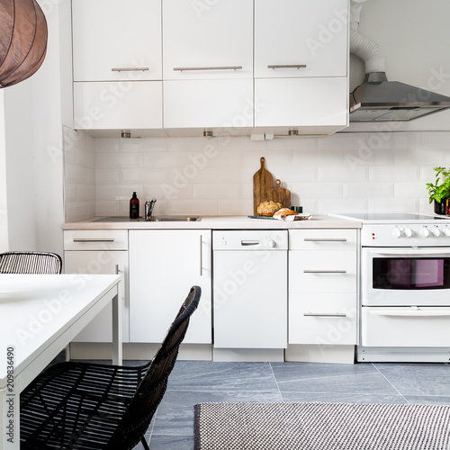 modern scandinavian kitchen with white cupbaords en grey tiles photo