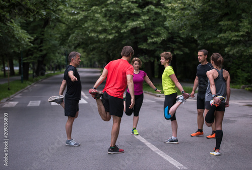 Fototapeta Naklejka Na Ścianę i Meble -  runners team warming up and stretching before morning training