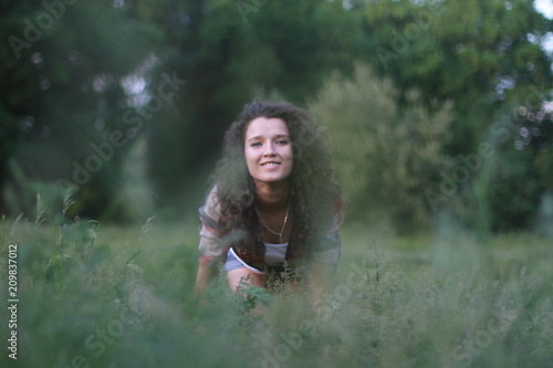 Fototapeta Naklejka Na Ścianę i Meble -  Young, beautiful woman on nature. Young woman with dark curly hair.