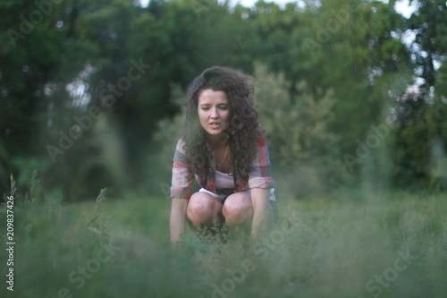 Young, beautiful woman on nature. Young woman with dark curly hair. © Ярослава Минаева