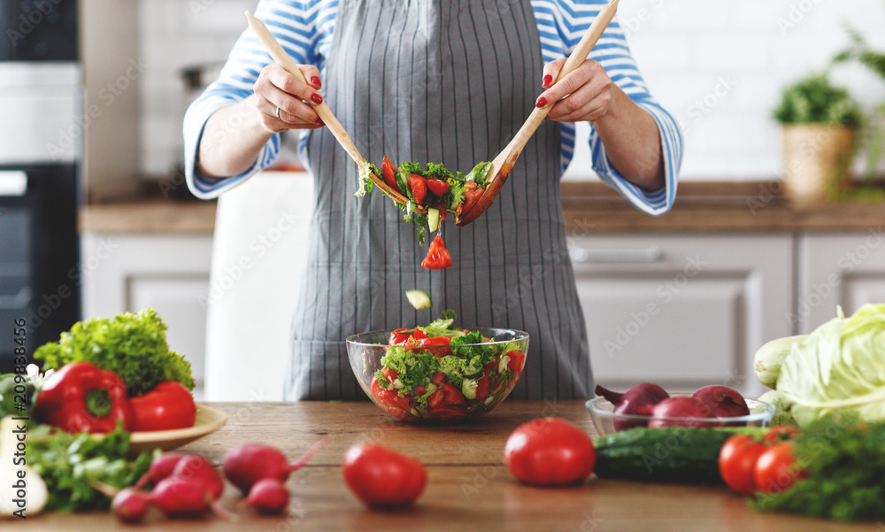 happy woman preparing vegetable salad in the kitchen. happy woman preparing vegetable salad in the kitchen.