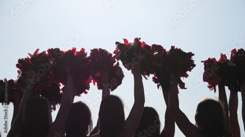 Cheerleader young girls team raise hands sway wag pom-poms during performance show