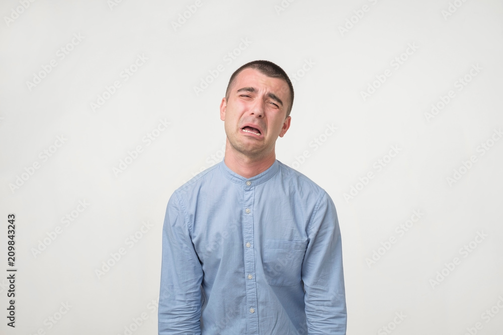 Studio shot of young handsome man, pouting and crying, complaining about girlfriend. Studio shot of young handsome man, pouting and crying, complaining about girlfriend.