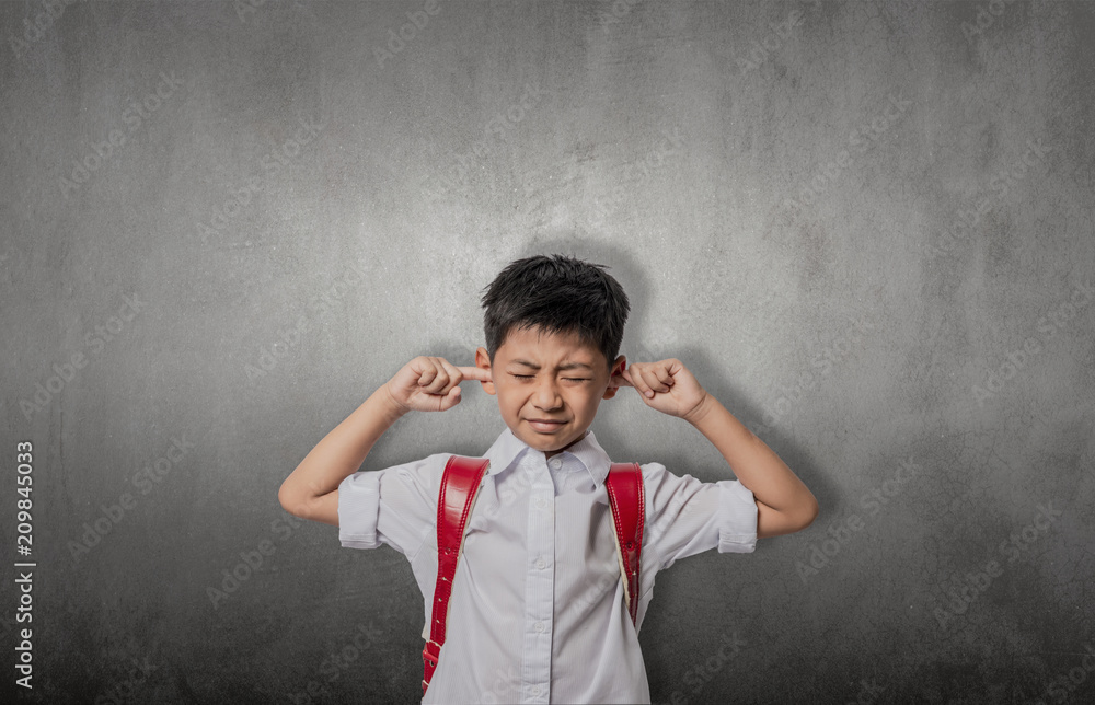 asian kid annoyed sticking fingers in ears with eyes closed, not listening to loud noise, ignoring stressful environment, stubborn teen refuses hearing, feels ear ache, tinnitus, concept idea..