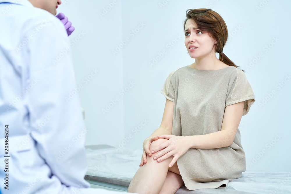 Fototapeta premium Crop view of anxious female sitting in medical office