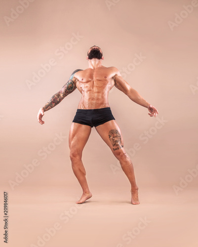 Muscular young fitness sports man with strong fit body on light background. © Mike Orlov