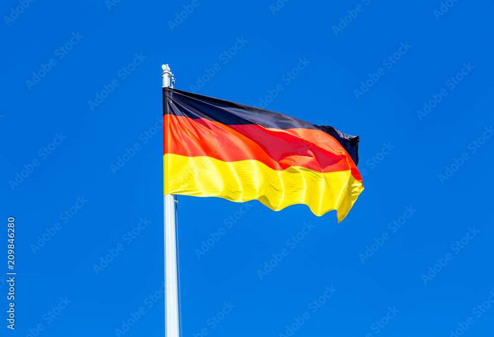 Flag of Germany flying in the wind against the sky Flag of Germany flying in the wind against the sky