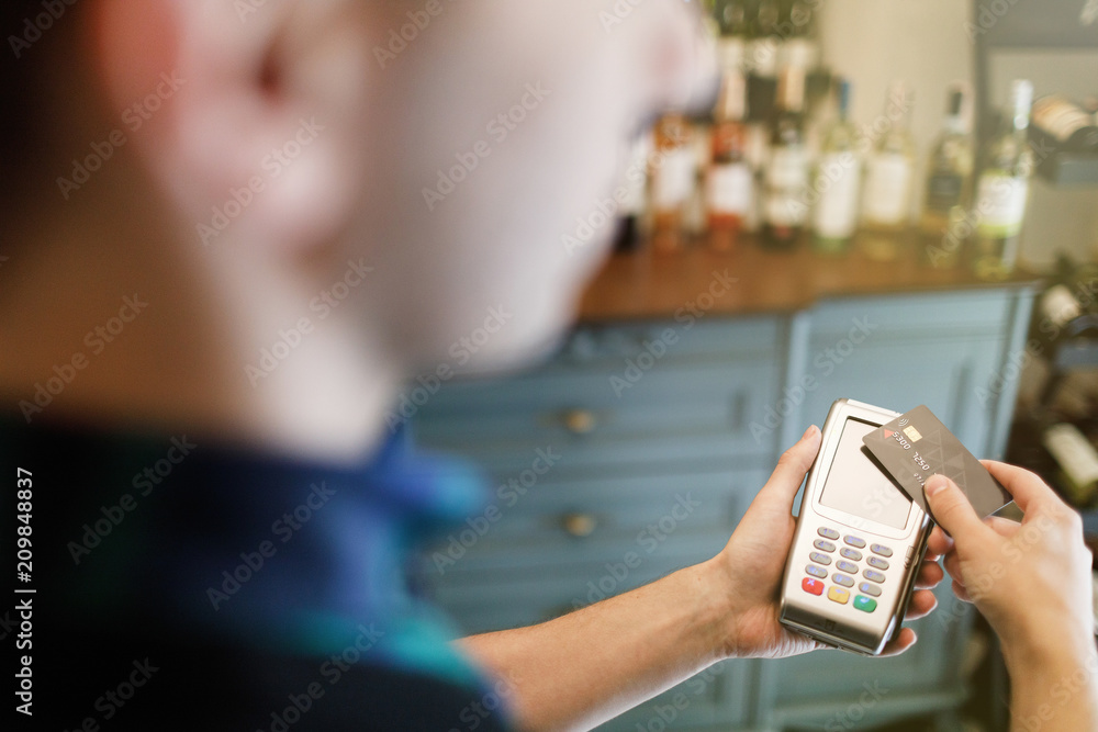 Hand of customer paying with contactless credit card with NFC technology. Hand of customer paying with contactless credit card with NFC technology.