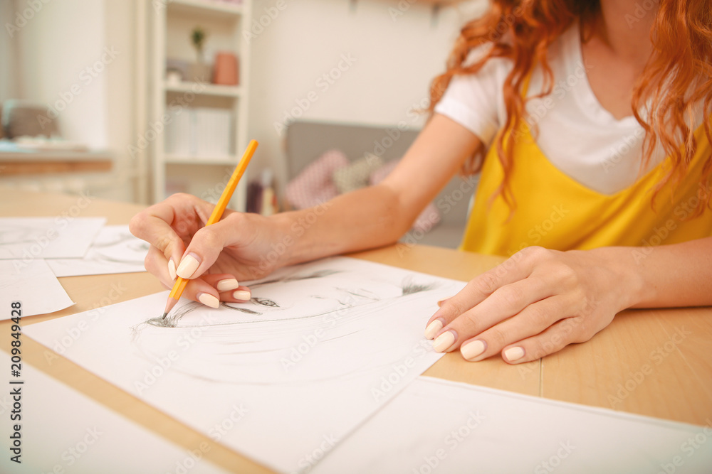 Drawing picture. Woman wearing bright yellow shirt enjoying her weekend at home while drawing nice picture