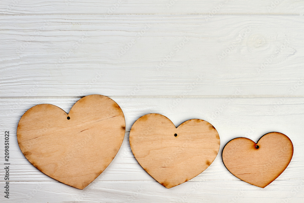 Fototapeta premium Three wooden hearts and copy space. Row of blank plywood hearts and space for text.