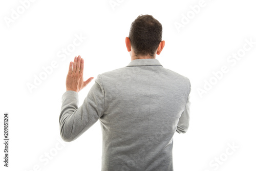 Back view of business man showing oath gesture