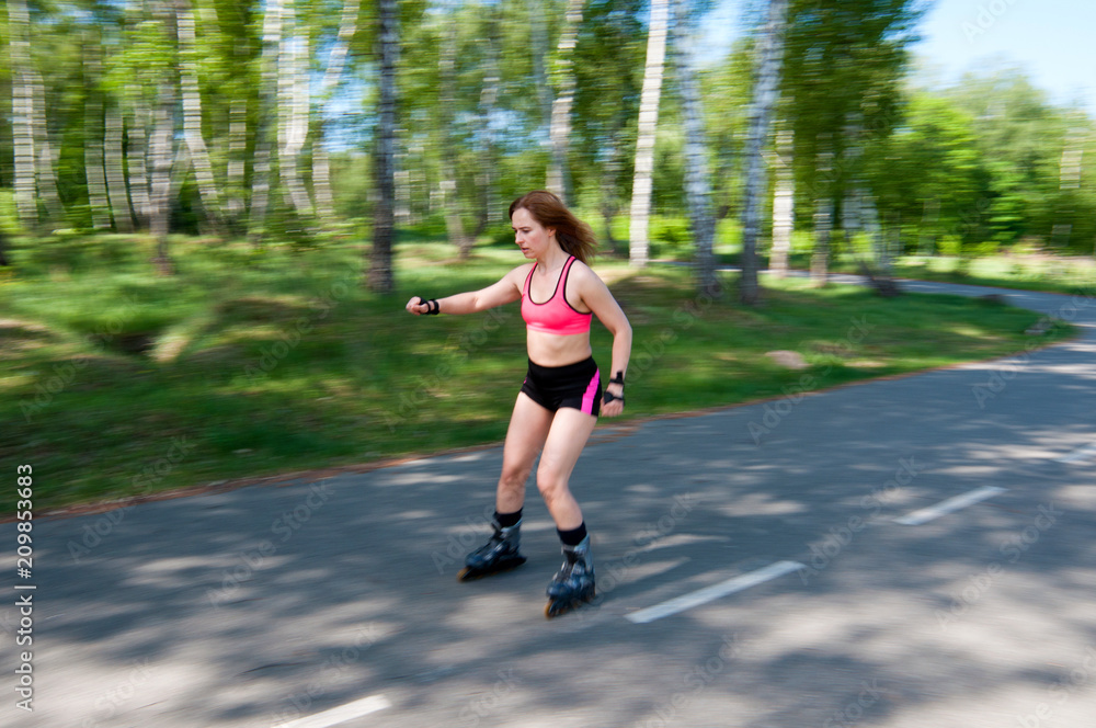 Roller skating woman in park rollerblading on inline skates. Beautiful woman learns to roller skate in the park. Rear view, front view, side view