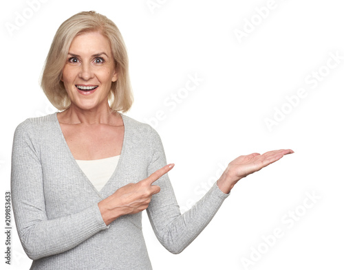 middle aged lady pointing to copyspace