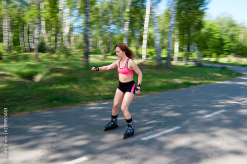 Roller skating woman in park rollerblading on inline skates. Beautiful woman learns to roller skate in the park. Rear view, front view, side view