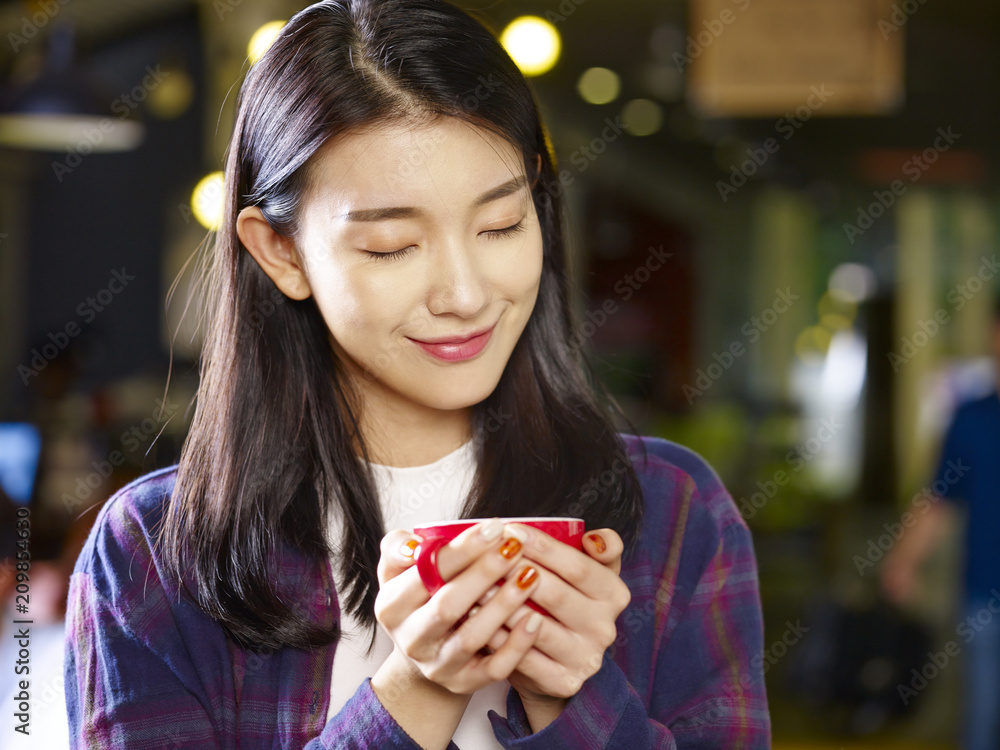 beautiful young asian woman holding a cup of coffee beautiful young asian woman holding a cup of coffee