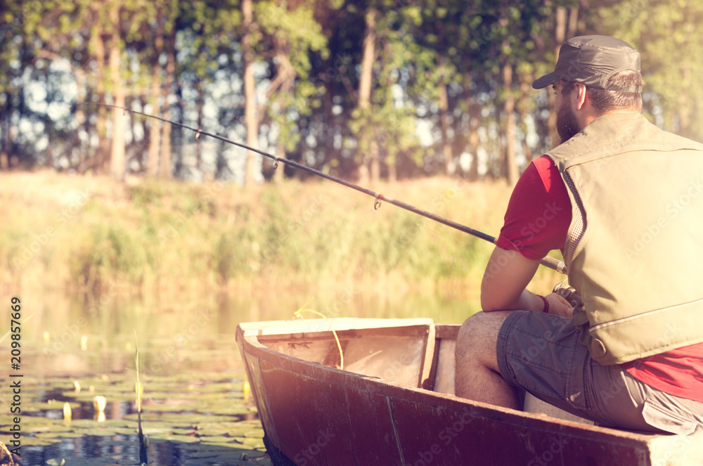 Man fishing in river from boat