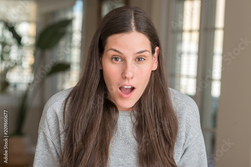 Young beautiful woman at home afraid and shocked with surprise expression, fear and excited face.