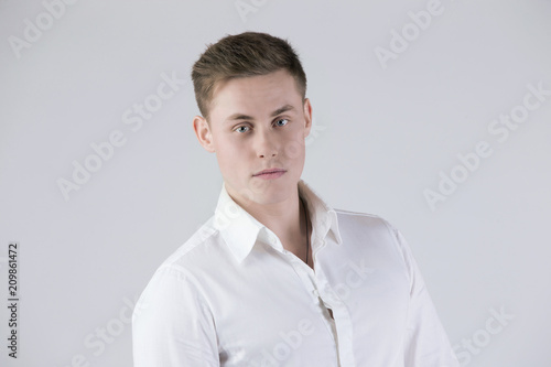 Beautiful blonde man in a white shirt on a white background © Светлана Лазаренко