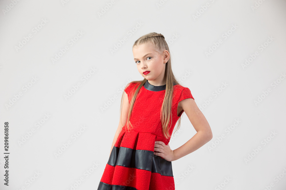 A teenaged blond girl in a red dress and brightly red lips on a white background A teenaged blond girl in a red dress and brightly red lips on a white background