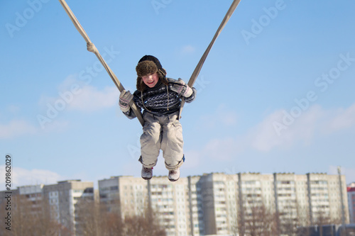 The child is riding high on a swing from the rope
