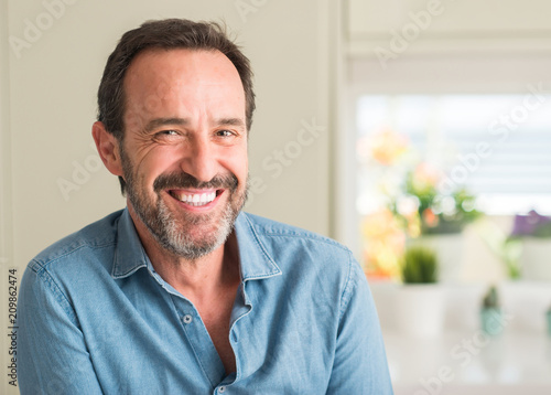 Handsome middle age man with a happy face standing and smiling with a confident smile showing teeth photo