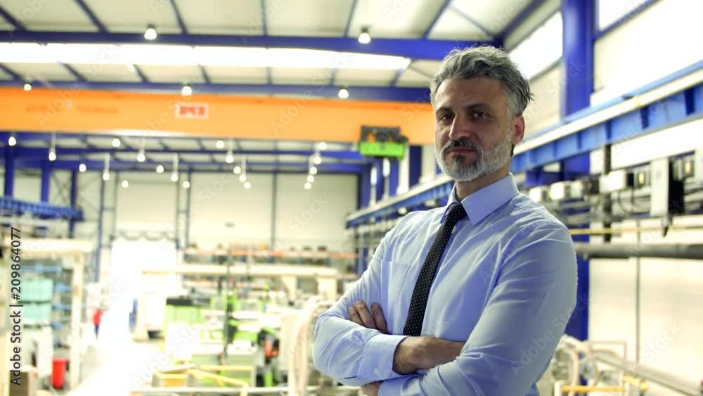 An industrial man engineer standing in a factory. Copy space. An industrial man engineer standing in a factory. Copy space.