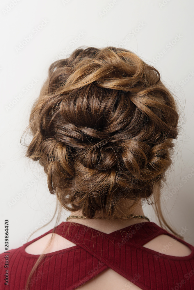 Wedding hairstyle bun on the head of brown-haired women on a gray background close-up rear vie Wedding hairstyle bun on the head of brown-haired women on a gray background close-up rear vie