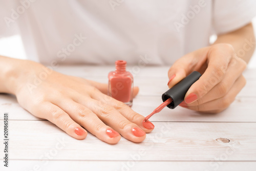 woman cover her nails with red varnish