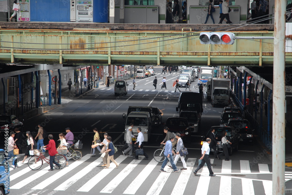 Obraz premium 横断歩道を渡る人々 駅 線路 高架