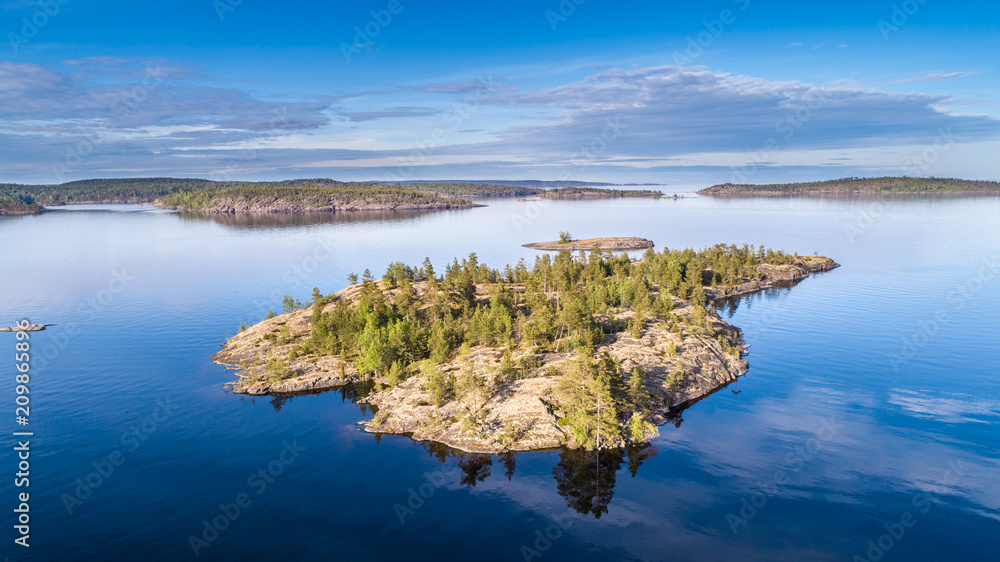 Nature of Russia. The Republic of Karelia. Reflection of clouds in the water. Islands on the horizon. Wild nature. Calm on the lake. Karelia Ladoga Lake.