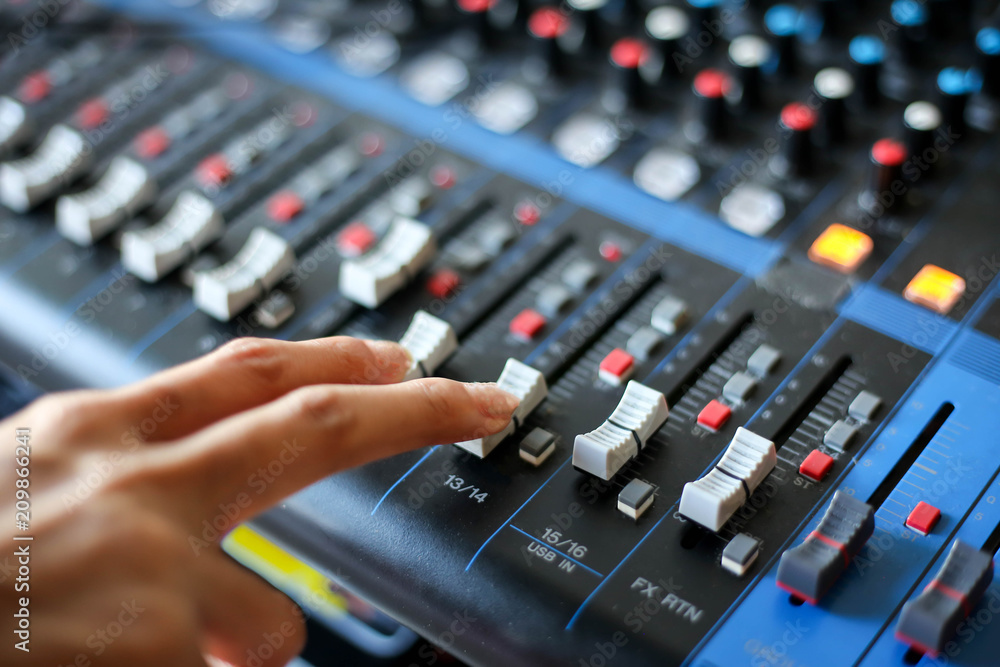 hand using mixing console,Sound recording studio mixing desk with engineer or music producer